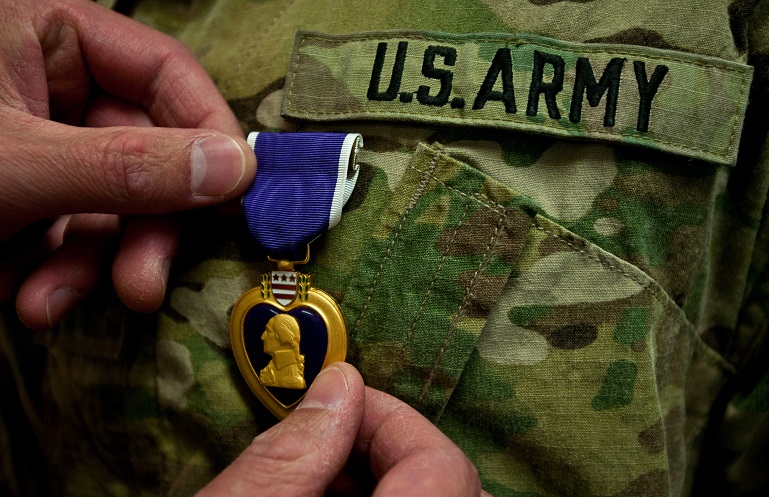 Un ufficiale appunta la Purple Heart sull'uniforme di un soldato ferito in combattimento