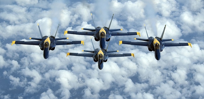 I Blue Angels, la pattuglia acrobatica della Marina americana, vola in formazione con quattro F-18 Hornet, come quelli resi celebri dal film "Tiop Gun" e stilizzati sulla nuova moneta ideata da CIT Coin Invest per Cook Islands