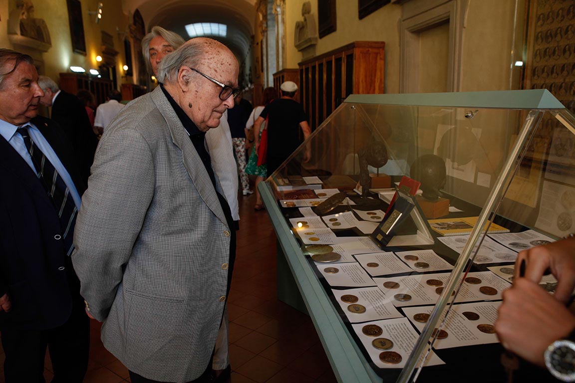 Duilio Donati osserva, da competente appassionato, una delle bacheche allestite con le medaglie e le sculture di Giannantonio Bucci alla Biblioteca Classense di Ravenna
