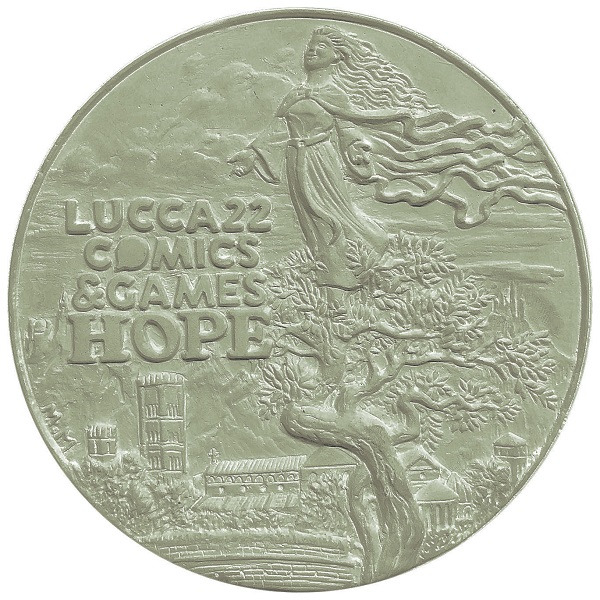 Il modello in gesso da cui nasce la medaglia ufficiale di Lucca Comics & Games 2022 riprende la locandina del grande raduno che si svolgerà dal 28 ottobre al 1° novembre prossimo