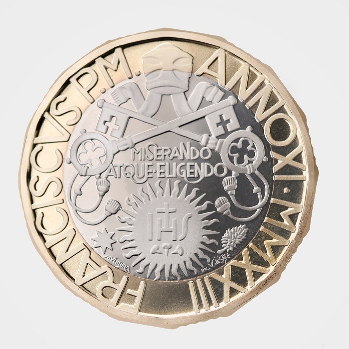 Ricorda un antico rosone da cattedrale la composizione di iscrizioni e simboli che sulla moneta declina, in modo quanto mai originale, lo stemma di papa Francesco
